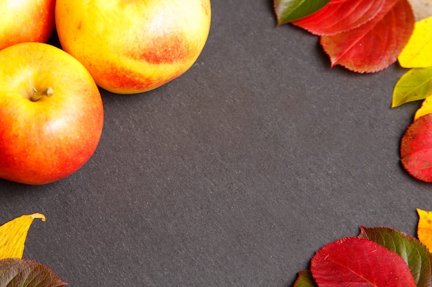 Thanksgiving background with apples and fall leaves.