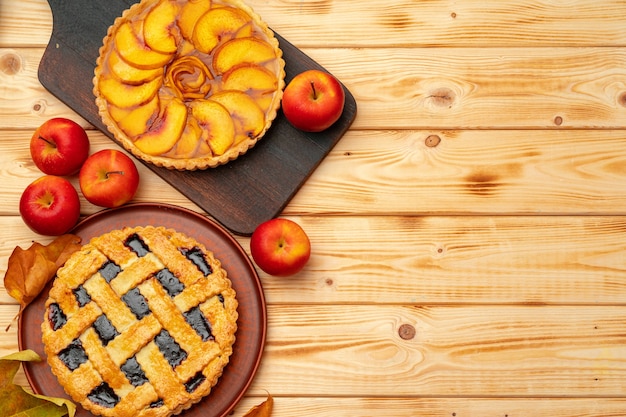 Thanksgiving berry and apple pies on wooden surface