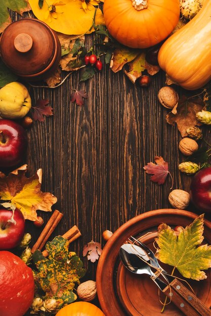 Thanksgiving day concept Autumn background from fallen leaves and fruits with vintage table setting on old wooden table