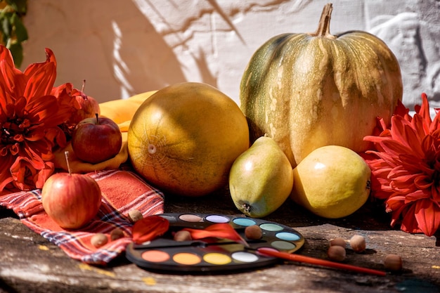 Thanksgiving Day-concept Herfst esthetische eerlijke gele fruitgroenten en heldere verven met een borstel pompoen, peren, appel en meloen Herfststilleven met rode georgine moderne schaduwen