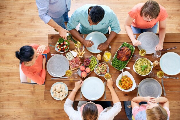 Foto giorno di ringraziamento concetto di cibo e svago gruppo di persone che cenano a tavola con il cibo