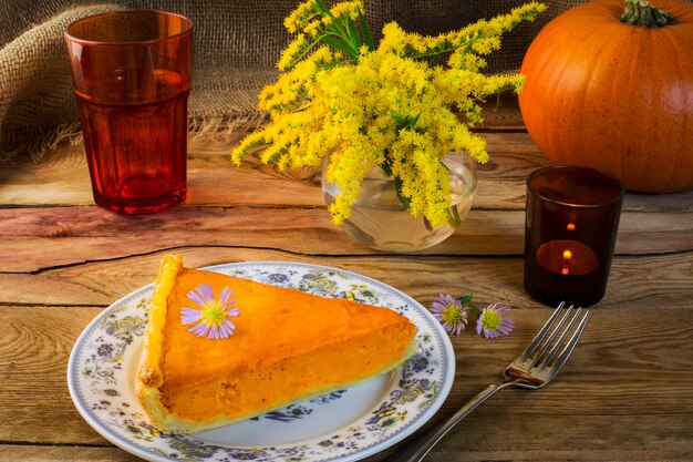 Thanksgiving pumpkin pie slice on the old wooden table 