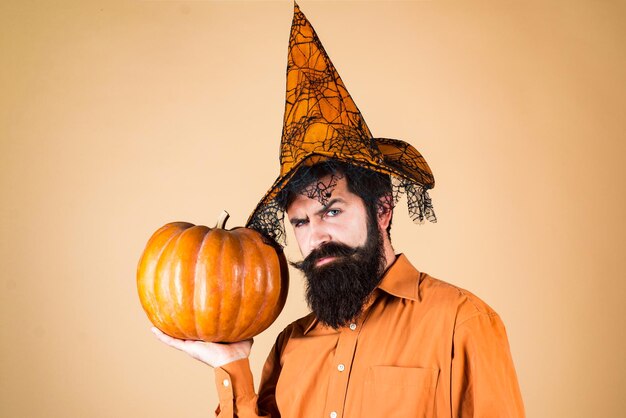 Photo thanksgiving seasonal cooking ingredients scary hipster man with beard in halloween hat trick or tre