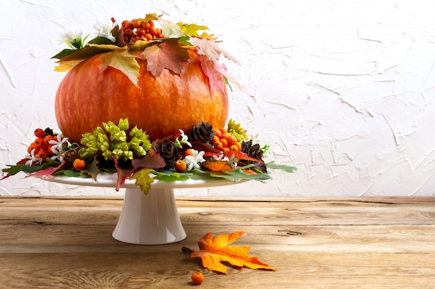 Photo thanksgiving table centerpiece with pumpkin, seeds and cones, copy space.