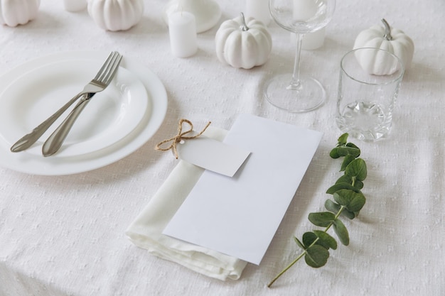 Сервировка стола на День Благодарения, посуда и украшения Пустая белая открытка на макете стола