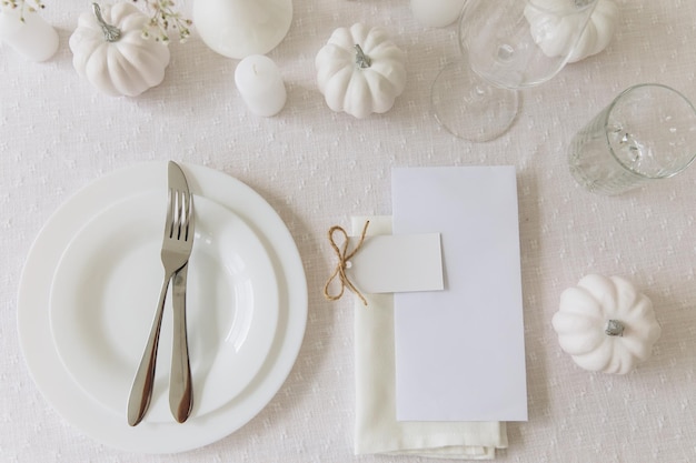 Foto stoviglie e decorazioni per la tavola del ringraziamento cartolina bianca vuota sul mockup del tavolo