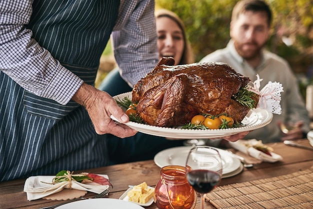 Thanksgiving-tafel en gebraden vlees op feest voor diner, lunch of avondmaal tijdens een openluchtevenement Kerstbijeenkomst en chef-kok die mensen een luxe maaltijd of feestmaal serveert voor een feestelijk kerstdiner