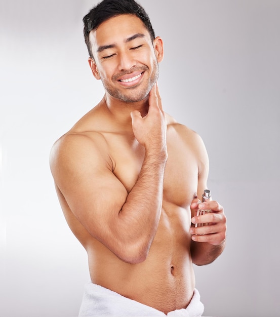That DOES smell like rocky mountain freshness Studio shot of a handsome young man applying aftershave