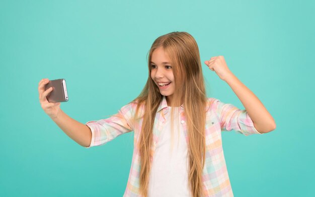 That is just amazing. Watching video on mobile device. Little girl using mobile phone. Small girl child with smartphone. Adorable child learning new technology. Cute mobile phone technology user.