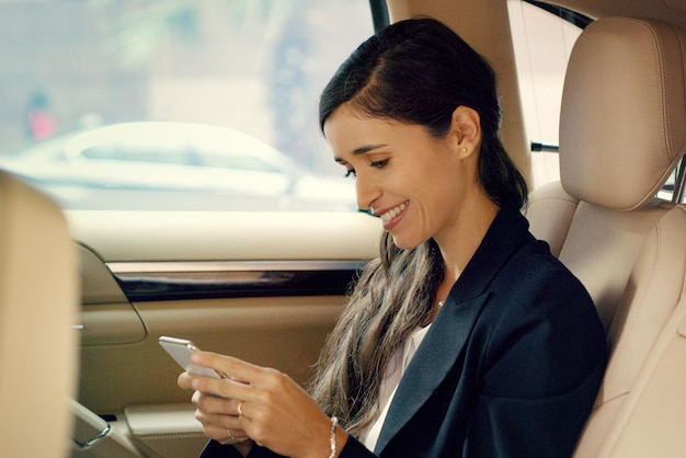 That one specific morning text can change your whole day Shot of an attractive young businesswoman using her cellphone inside a car while traveling to work