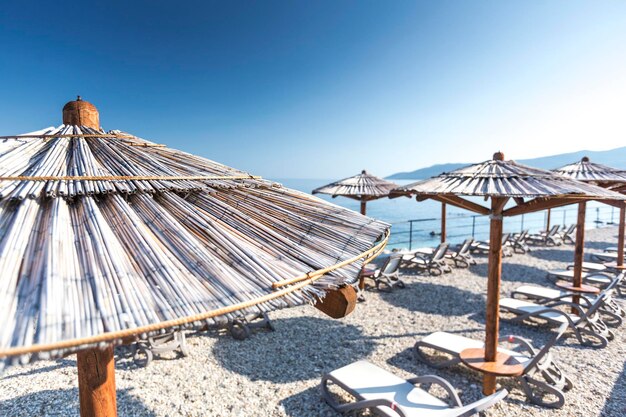 Photo thatched roofs at beach against blue sky on sunny day