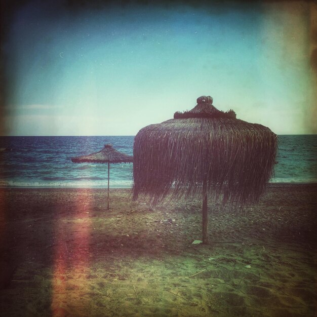 Foto tetti di paglia su una spiaggia tranquilla