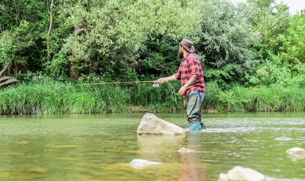 The Addiction is Real sportactiviteit hobby ervaren visser in het water Succesvol vliegvissen zomerweekend man vis vangen volwassen man vliegvissen visser show vistechniek gebruik hengel