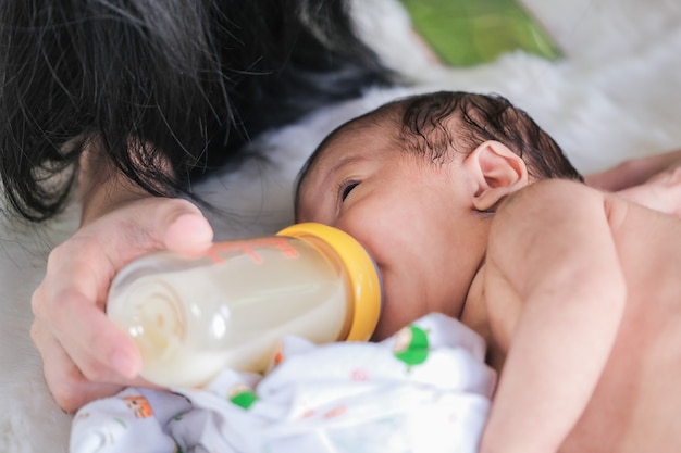 写真 赤ちゃんは母親が与えるボトルから飲みます。