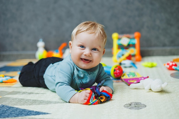 사진 아기는 열 매트에 누워서 놀고 있습니다. 신생아의 자기 발달 어린이 발달용 장난감