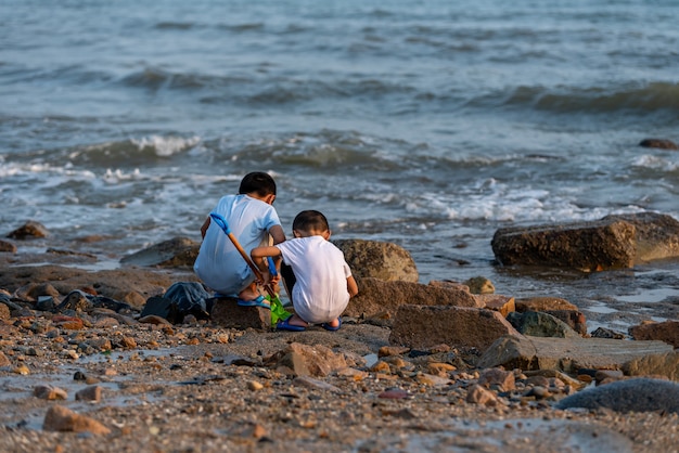 사진 해변 상류에서 노는 두 아이의 뒷모습.