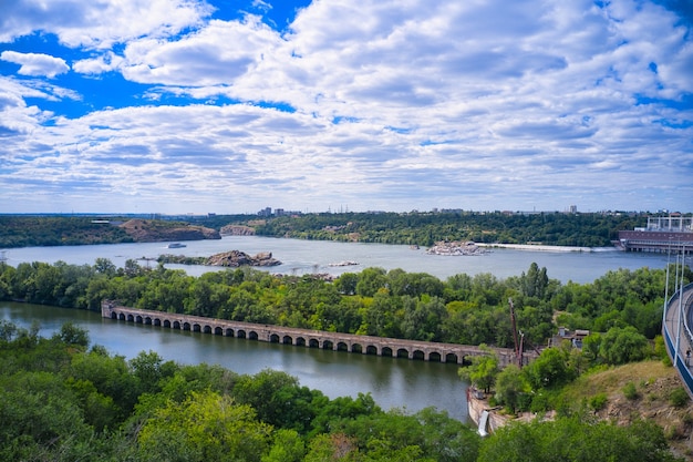 Фото Красивая река окружена зеленой и свежей растительностью в городе.