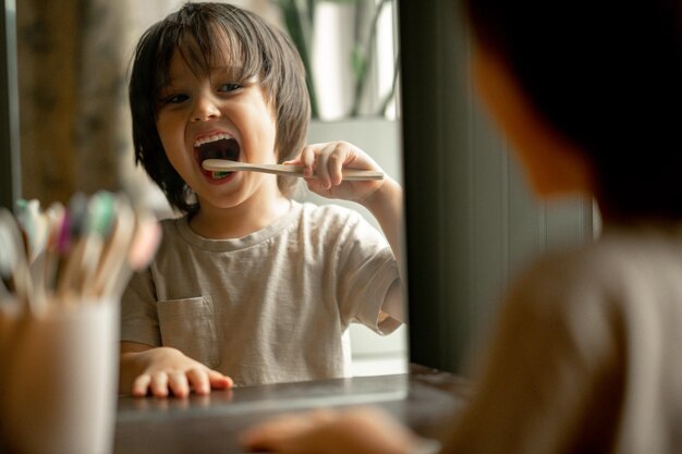 写真 その少年は生態学的な素材で作られた歯ブラシで歯を磨く