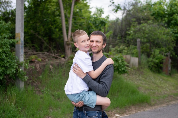 写真 お父さんの腕の中で少年はカメラを見て微笑む