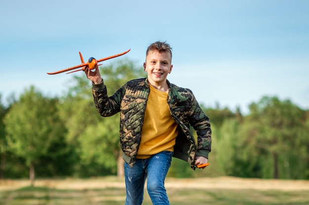 Мальчик запускает игрушечный самолетик.