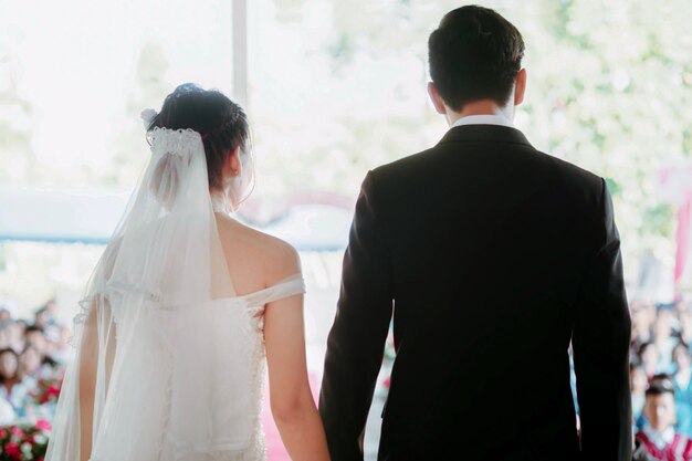 写真 新郎新婦はソフトフォーカスで手を握ります。結婚式の日の幸せの写真。