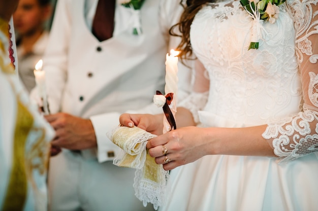 신부, 신랑 손에 결혼식 촛불을 보유합니다. 촛불 굽기
