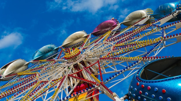 写真 青空を背景に回転する遊園地のカルーセル子供向け遊園地