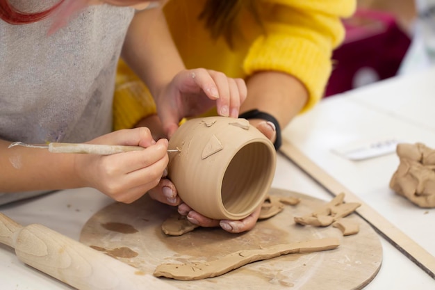 写真 子供の手が粘土カップを作る 粘土製品のマスタークラス