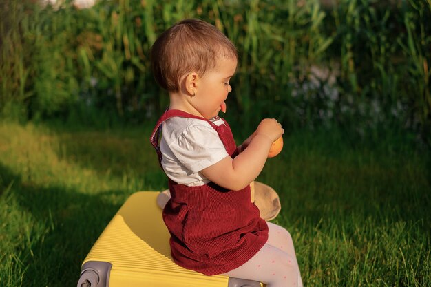 写真 子供はスーツケースの上に座り、目を閉じると旅行冒険休暇の夢を見る