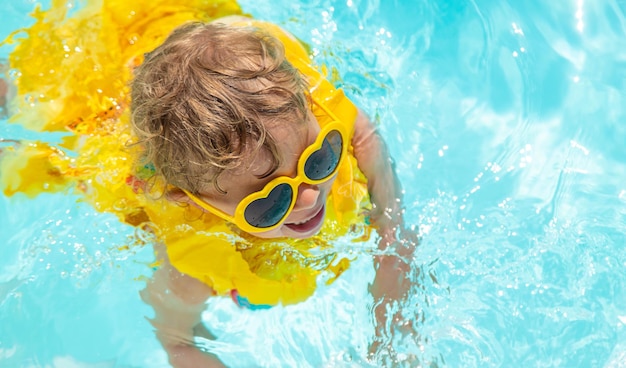 Фото Ребенок плавает в бассейне в жилете выборочный фокус