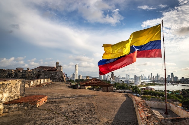 Колумбийский флаг в картахенском форте в пасмурный и ветреный день. картахена, колумбия