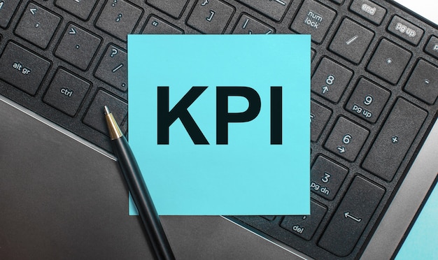 На клавиатуре компьютера есть ручка и синяя наклейка с текстом kpi. плоская планировка.