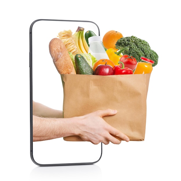 食品と食料品の配達の概念スマートフォンで食品の袋を持った手