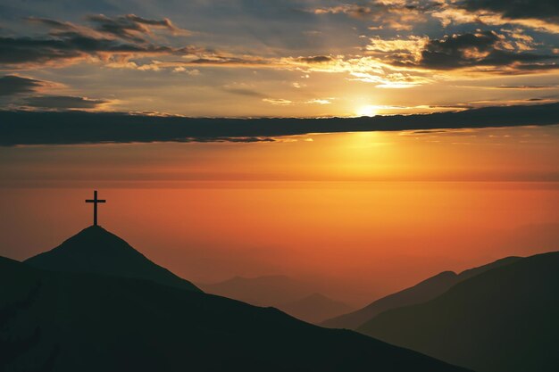 写真 崖と山の上でのイエス・キリストの磔刑の磔刑 夕日の光を選択してください