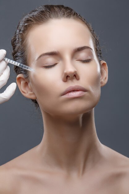 写真 医師美容師は若返り顔面注射の手順を行います