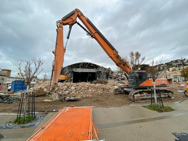 Фото Экскаватор-погрузчик во время сноса зала триповичей в триесте