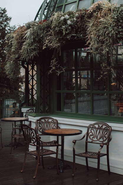 Фото Фасад кафе украшен растениями и цветами. деревянный стол и стулья в винтажном стиле.