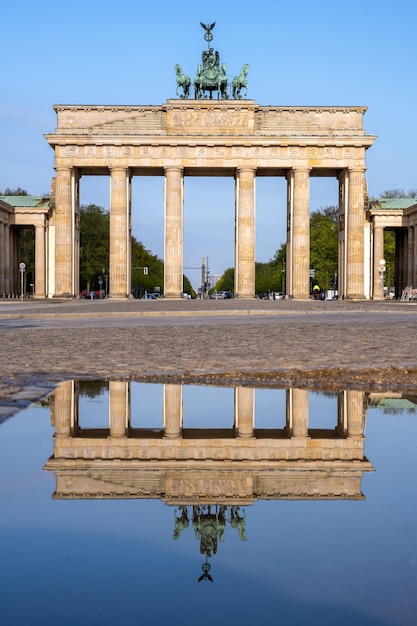 Фото Знаменитый бранденбургский тор в берлине без людей, отраженных в луже.