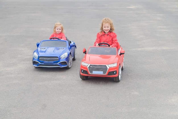 写真 道路の子供で車の電気自動車を運転している女の子