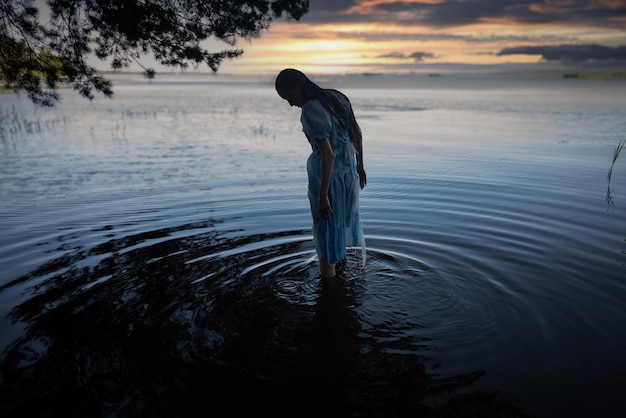 사진 파란 드레스를 입은 소녀는 호수에 익사하기로 결정했습니다.
