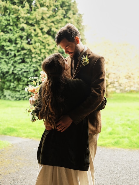Фото Жених обнимает невесту в пасмурный день, любовь, поцелуй и нежность в объятиях