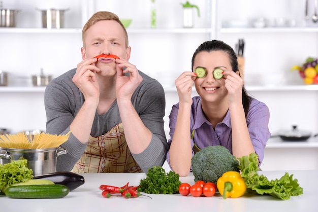 男と女は台所で野菜と遊ぶ。