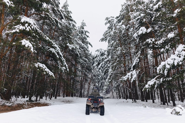 男は雪の天気の中でバイクに乗る