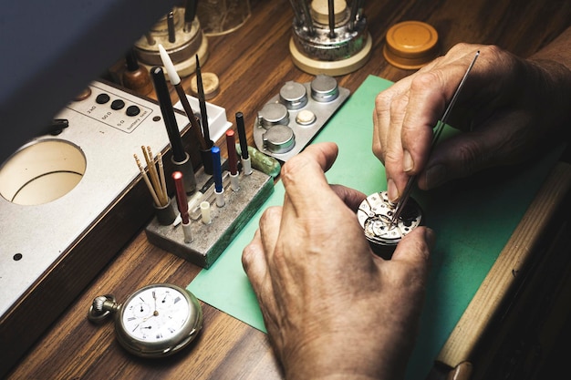 写真 腕時計を修理する時計師の手