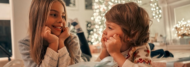 写真 床に横たわっている贈り物を持つ幸せな女の子と男の子