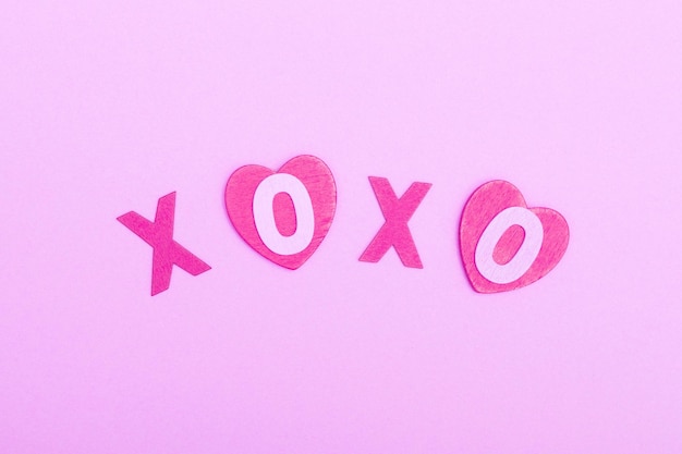 사진 분홍색 배경에 있는 나무 글자로 된 xo xo라는 문구는 valentine39s 데이 러브 데이트와 결혼의 개념 키스 심볼 플랫 레이 미니멀리즘