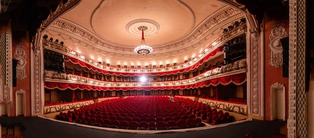 写真 赤い座席とバルコニーのある空の劇場の中央ゴールデン ホールのインテリア 古典的なバロック様式の豪華な劇場ホール