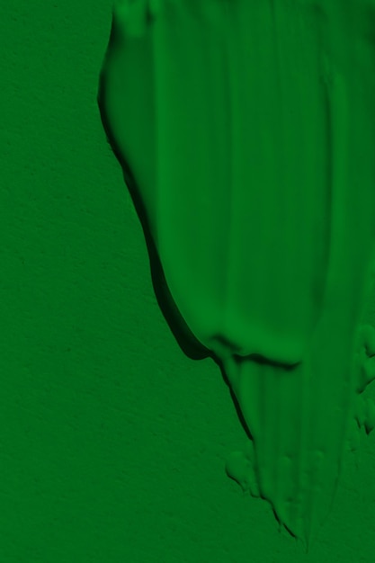 Фото Неплотная текстура зеленой краски размазанная краска представляет собой жидкий зеленый цвет фон зеленого цвета выпадом растекается на свету наносится на поверхность травянистой натуральной