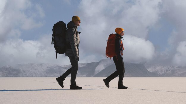 写真 雪山を背景にバックパックを背負った男女