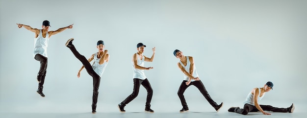 Фото Человек танцует фитнес или хореографию хип-хопа на серой поверхности студии